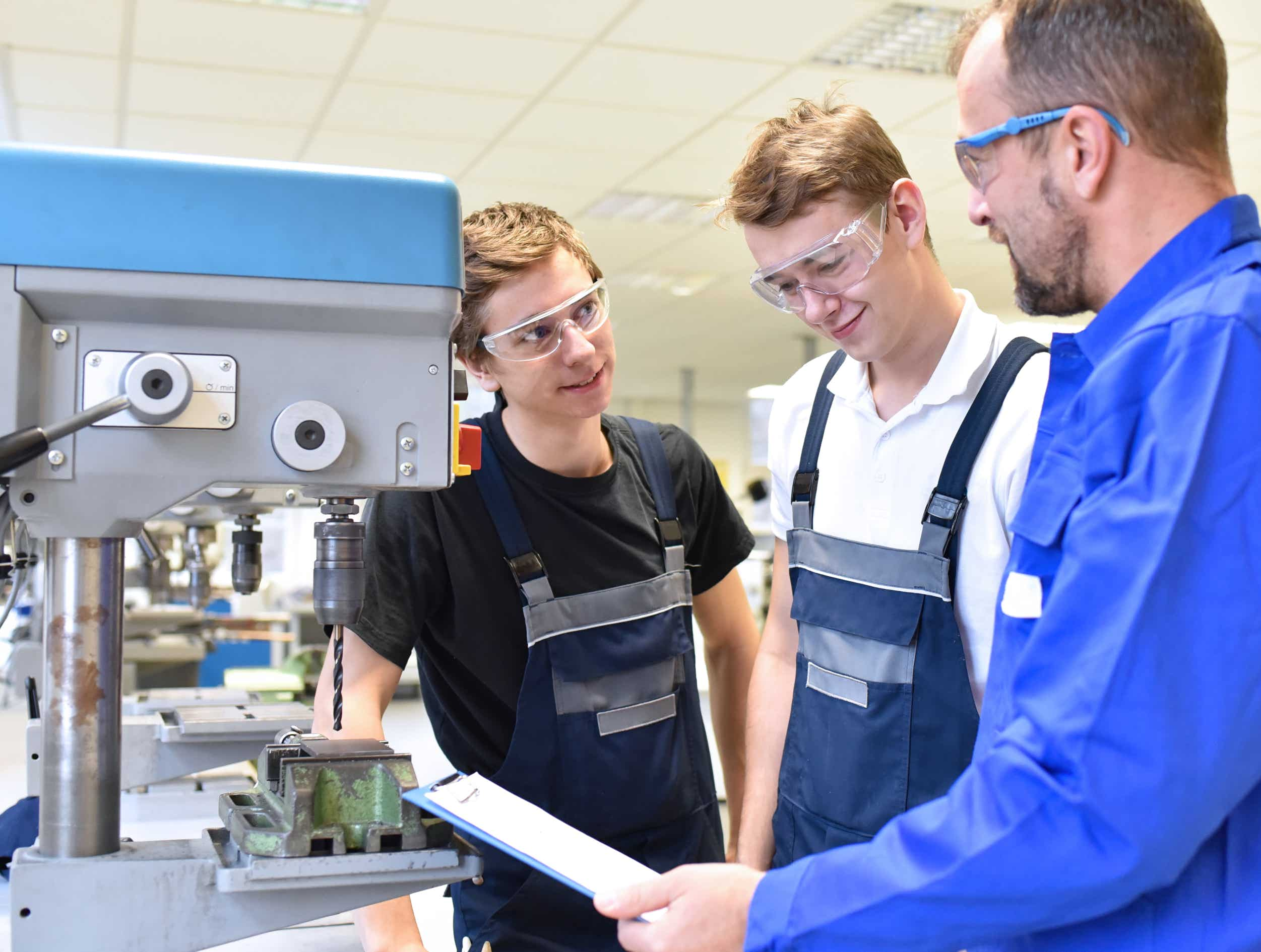 Schüler mit Meister an einer Maschine